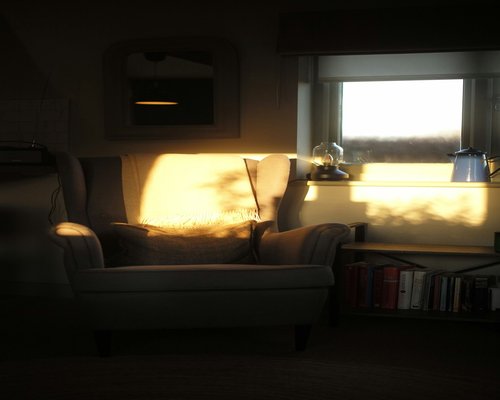 Soft indirect background lighting setup in a quiet reading corner of a modern Chilean living room